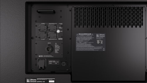 Nahaufnahme der Rückseite eines elektronischen Geräts mit verschiedenen Eingangs-/Ausgangsanschlüssen, Warnhinweisen und einem Lüftungsgitter. Die Marke Meyer Sound ist sichtbar.