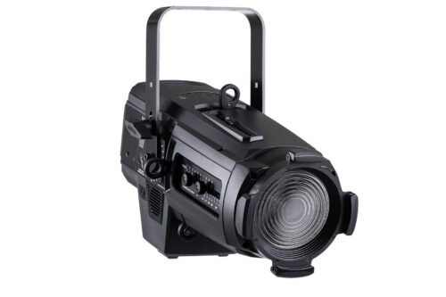 Ein schwarzer Bühnenscheinwerfer mit einem Griff an der Oberseite, Bedienknöpfen an der Seite und einer großen Linse an der Vorderseite, isoliert auf weißem Hintergrund.